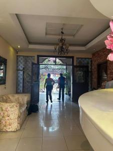 two men walking into a room with a door at Hotel Aloha Managua in Managua