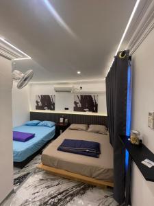 a bedroom with two beds and a mirror at Z&Z Budget Room in Kampung Kuala Besut