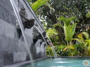 a fountain in the middle of a swimming pool at Sananda Aryani in Lovina