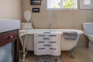 a bathroom with a bath tub and a sink at L'Appartement Bleu in Waiheke Island +14 photos