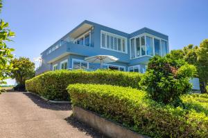 a blue house with an umbrella in front of it at L'Appartement Bleu in Waiheke Island