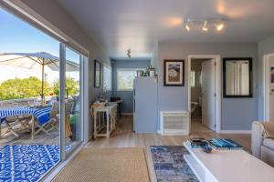 a living room with a refrigerator and a table at L'Appartement Bleu in Waiheke Island