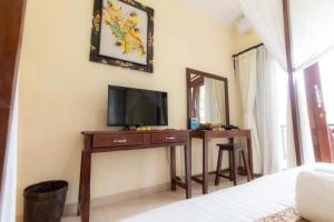 a bedroom with a tv on a table with a mirror at Secret Forest Hideaway near Ubud in Bangli