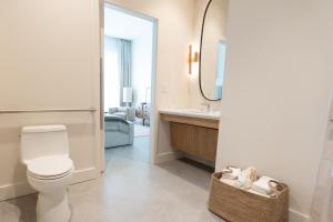ein Badezimmer mit Toilette, Waschbecken und Spiegel in der Unterkunft The Sitio in Virginia Beach
