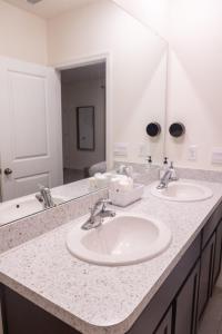 a bathroom counter with two sinks and a mirror at South Shore Suites in Wimauma +50 photos