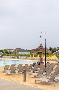 a bunch of lounge chairs on a beach at South Shore Suites in Wimauma