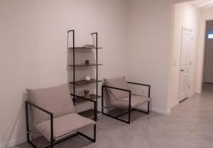 two chairs and a book shelf in a room at South Shore Suites in Wimauma