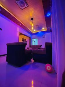 a room with purple lights and couches in a room at Sigiri Gateway in Galewela