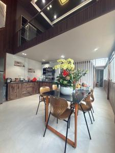 a dining room with a table with flowers on it at Ánh Dương House 2 in Da Thanh
