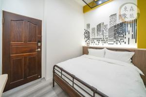 a bedroom with a bed and a brown door at 水母漂民宿-免費停車-寵物友善-無門禁24小時進出-東森文旅-包棟優惠中 in Toucheng