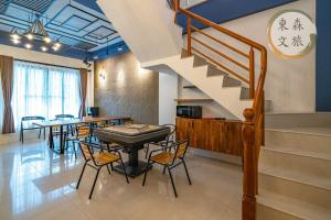 a dining room with a table and chairs and a staircase at 水母漂民宿-免費停車-寵物友善-無門禁24小時進出-東森文旅-包棟優惠中 in Toucheng +14 photos