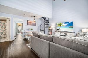 a living room with a couch and a television at Steps 2 beach Ocean view Pool Parking in Brigantine