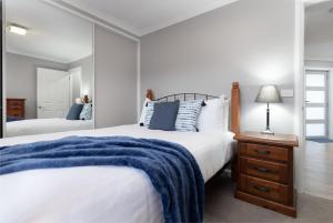 a bedroom with two beds and a mirror at Happy Tails Devonport in Devonport