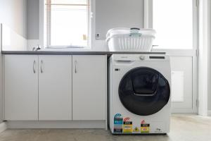 a washing machine sitting under a counter in a kitchen at Happy Tails Devonport in Devonport