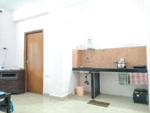 a kitchen with a table and a sink in a room at Rich nest apartments colva in Colva