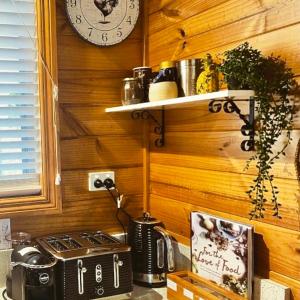 a kitchen with a stove and a clock on a wall at White Croft Cottage in Ross