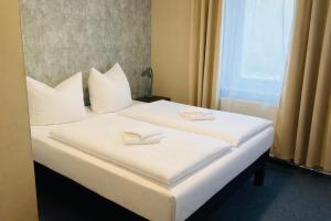 two beds in a hotel room with towels on them at Die Grenzburg in Güstrow