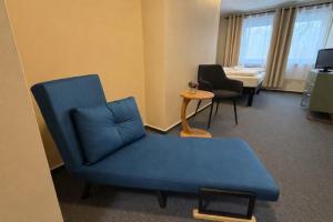a living room with a blue couch and a chair at Die Grenzburg in Güstrow