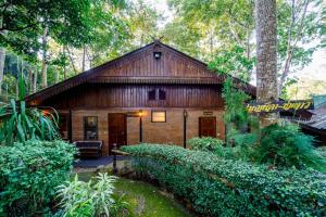a small wooden house in the woods with trees at Marisa Resort & Spa Chiang Dao in Ban Muang Ngai