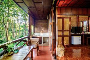 a room with a balcony with a table and a kitchen at Marisa Resort & Spa Chiang Dao in Ban Muang Ngai