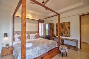 ein Schlafzimmer mit einem großen Bett mit Holzrahmen in der Unterkunft Hotel Sea Sapphire in Calangute