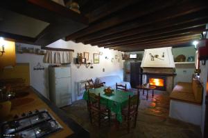 - un salon avec une table et une cheminée dans l'établissement Rancho Calvillo, à Prado del Rey