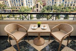 a table and two chairs on a balcony with a view at Arabella Residence 2BR - New Cairo Luxury Stay in Cairo