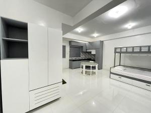 a white room with a bed and a table at Host Homes RM201 Independencia St in San Fernando