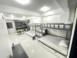 a room with three bunk beds and a desk at Host Homes RM201 Independencia St in San Fernando
