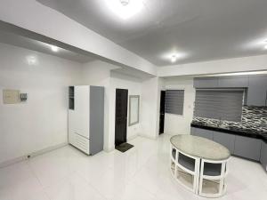 a kitchen with a table and a stool in a room at Host Homes RM201 Independencia St in San Fernando