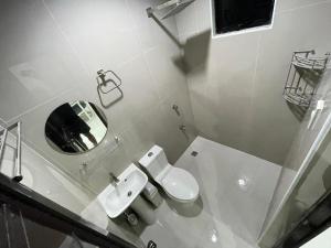 a bathroom with a toilet and a sink and a mirror at Host Homes RM201 Independencia St in San Fernando