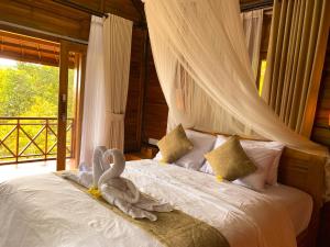 a bedroom with a bed with two swans on it at Wimala Farm House in Munduk
