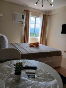 a room with a bed and a table and a window at Mountain View Studio at Marina Spatial - 300 Mbps, Pool, near Boulevard in Dumaguete +15 photos