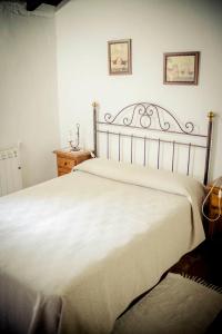 1 dormitorio con 1 cama blanca grande y 2 cuadros en la pared en Rancho Calvillo, en Prado del Rey
