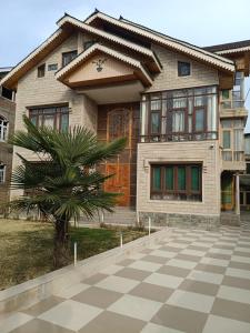 a house with a palm tree in front of it at p&q's guest house in Srinagar