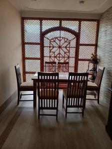 a dining room with a table and four chairs at p&q's guest house in Srinagar