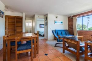 a living room with a table and chairs and a couch at 1 Still Breeze in Maroochydore
