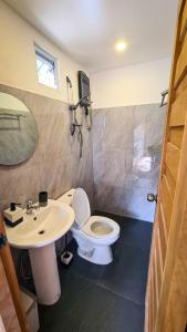 a bathroom with a toilet and a sink at Balay Mariposa in Langagan