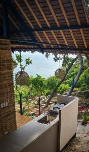 a kitchen with a sink and a view of the ocean at Balay Mariposa in Langagan +9 photos