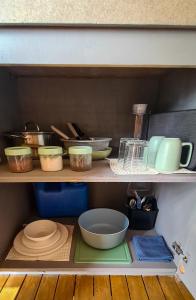 a shelf with bowls and other kitchen items on it at Balay Mariposa in Langagan