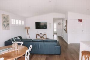 a living room with a blue couch and a table at Salt @ South West Rocks in South West Rocks