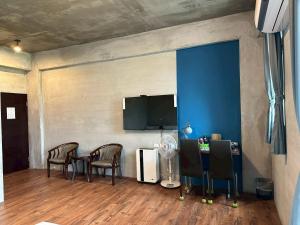 a room with chairs and a desk and a tv at Bear&Best Homestay in Yuli
