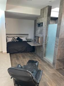 a black chair in a room with a bed at comfortable and nice loft, great location in Aguascalientes +5 photos