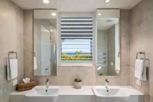 a bathroom with two sinks and a window at Beachside Bliss - Ocean View, Pool, Sauna in Peregian Beach