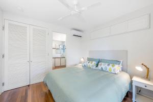 a white bedroom with a large bed and white cabinets at Beachside Bliss - Ocean View, Pool, Sauna in Peregian Beach