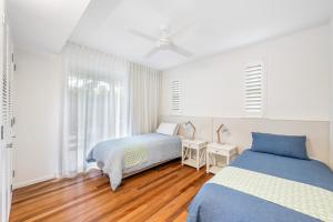 a bedroom with two beds and a window at Beachside Bliss - Ocean View, Pool, Sauna in Peregian Beach +28 photos