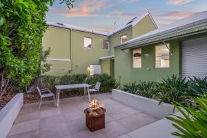 a patio with a table and chairs in front of a house at Beachside Bliss - Ocean View, Pool, Sauna in Peregian Beach