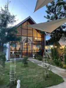a home with a large building with glass windows at มาทาเลรีสอร์ท in Ang Thong