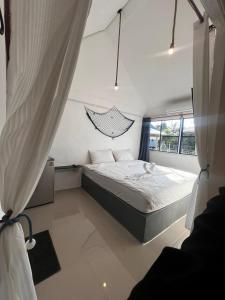 a small bedroom with a bed and a window at มาทาเลรีสอร์ท in Ang Thong