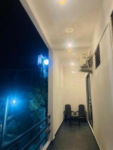two chairs sitting on a balcony at night at Luminozo Beach Hotel in Weligama